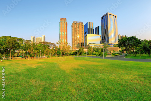 The green lawn in the evening has a city background.