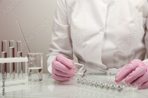 research work in the laboratory close up. scientist's hands in pink gloves 
