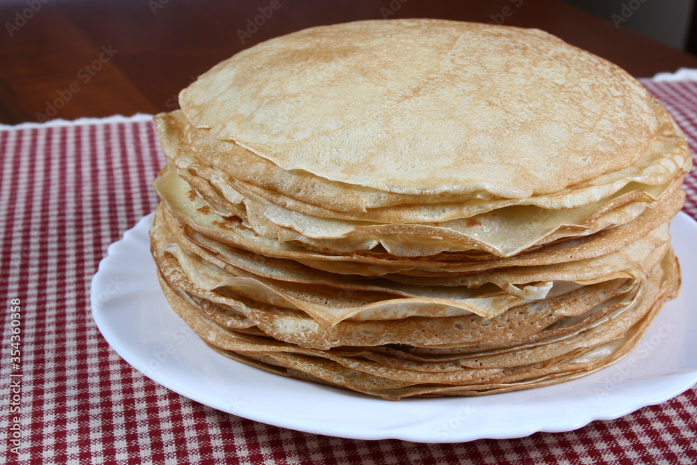 Thin pancakes on a white plate