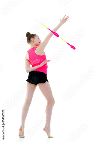 A girl gymnast performs exercises with a mace.