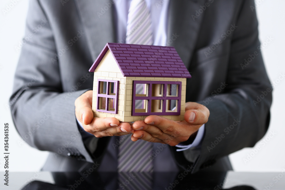 Elderly businessman demonstrating the model of house Elderly businessman demonstrating the model of house