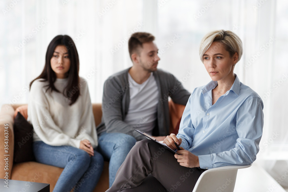 Psychologist Thinking How To Help Unhappy Couple Sitting In Office Psychologist Thinking How To Help Unhappy Couple Sitting In Office