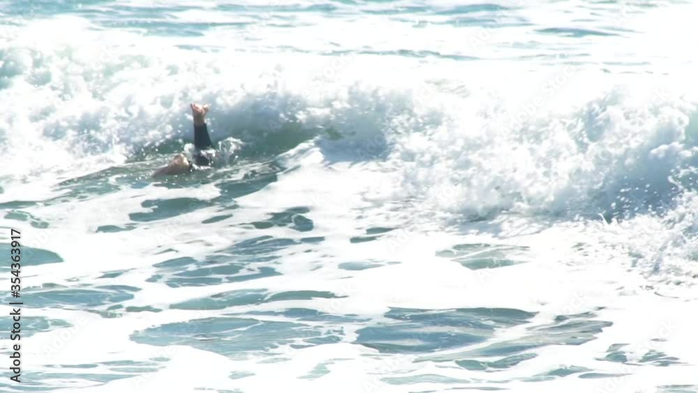 A surfer passing under the waves in Valencia in the Mediterranean Sea A surfer passing under the waves in Valencia in the Mediterranean Sea