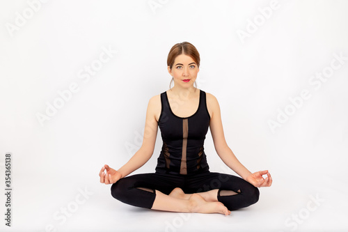 girl meditates after sports on a white background, healthy lifestyle, weight loss, space for text