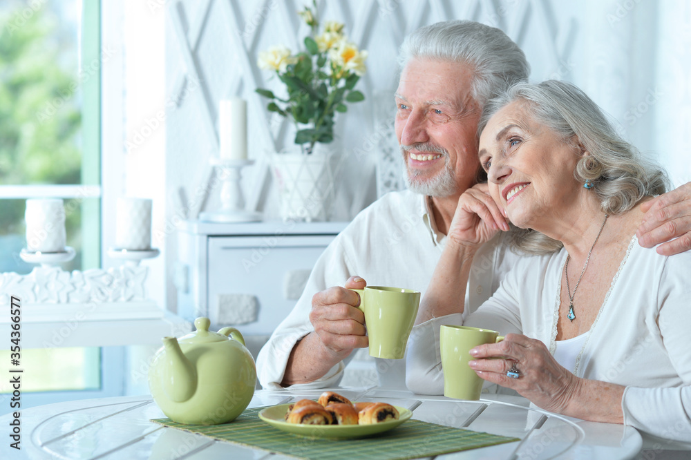 Portrait of mature couple drinking tea with cookies