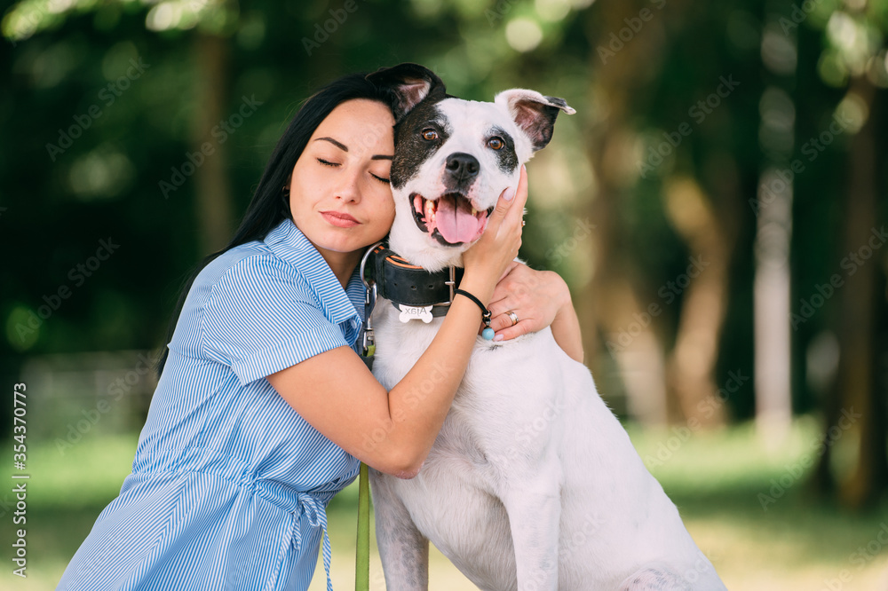 Beauteous woman sits with her lovely dog in the park and rejoices Beauteous woman sits with her lovely dog in the park and rejoices