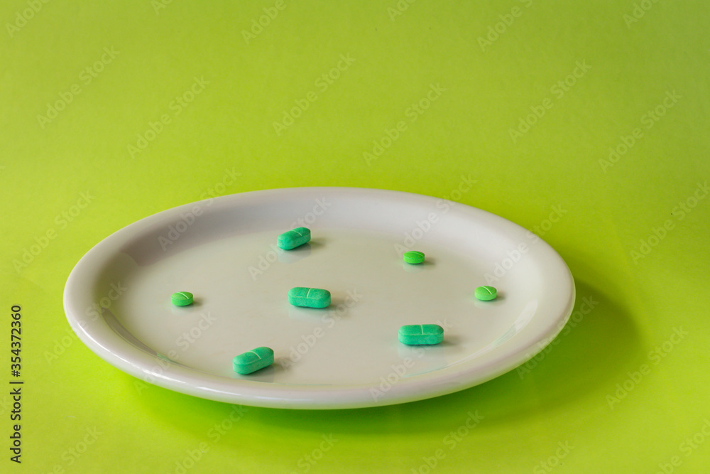 Colored pills on a white plate. Concept of social distancing. Colored pills on a white plate. Concept of social distancing.