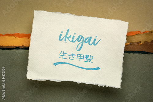ikigai - Japanese philosophy and life style  - a reason for being or a reason to wake up  - handwriting on a handmade rag paper against abstract landscape photo