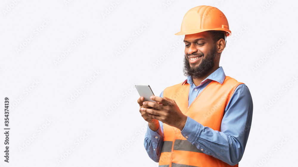 African Builder Worker Using Smartphone On White Studio Background, Panorama African Builder Worker Using Smartphone On White Studio Background, Panorama