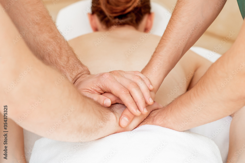 Thai back massage with four hands of back of young woman in massage salon. Thai back massage with four hands of back of young woman in massage salon.