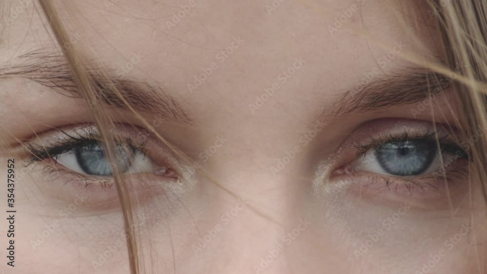 Eyes of a Beautiful Scandinavian Young Woman Looking Into Camera with Wind Blowing in Hair Close up.
