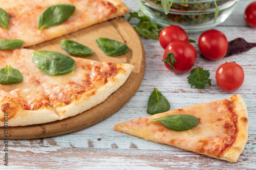 pizza with cheese sauce and spinach on wooden background