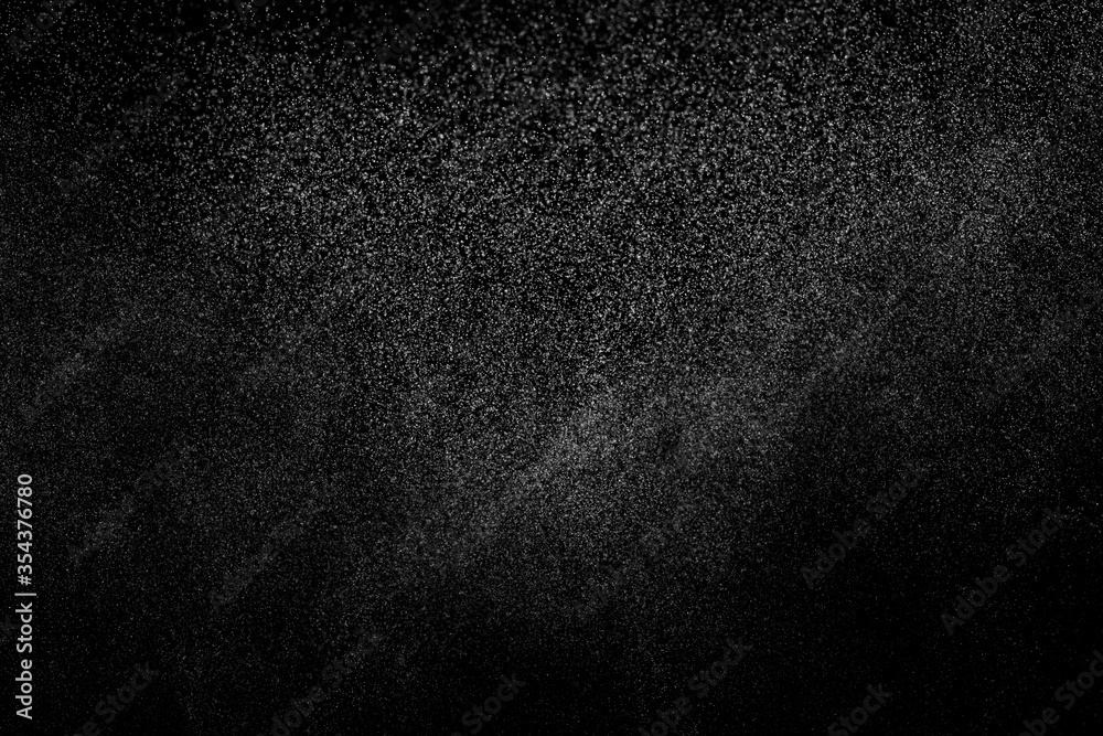Abstract splashes of water on black background. Freeze motion of white particles. Rain, snow overlay texture. Abstract splashes of water on black background. Freeze motion of white particles. Rain, snow overlay texture.