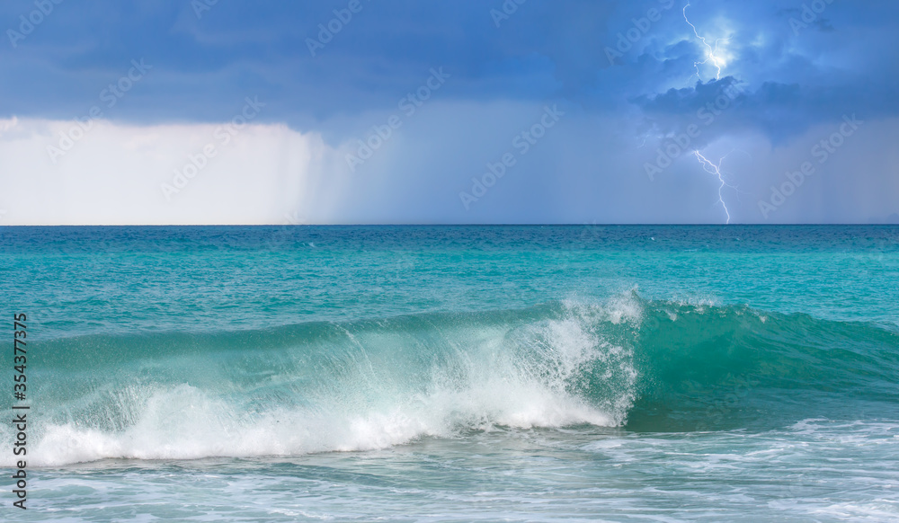 Tropical turqouise and blue sea under amazing stormy clouds with lightning and rainy day