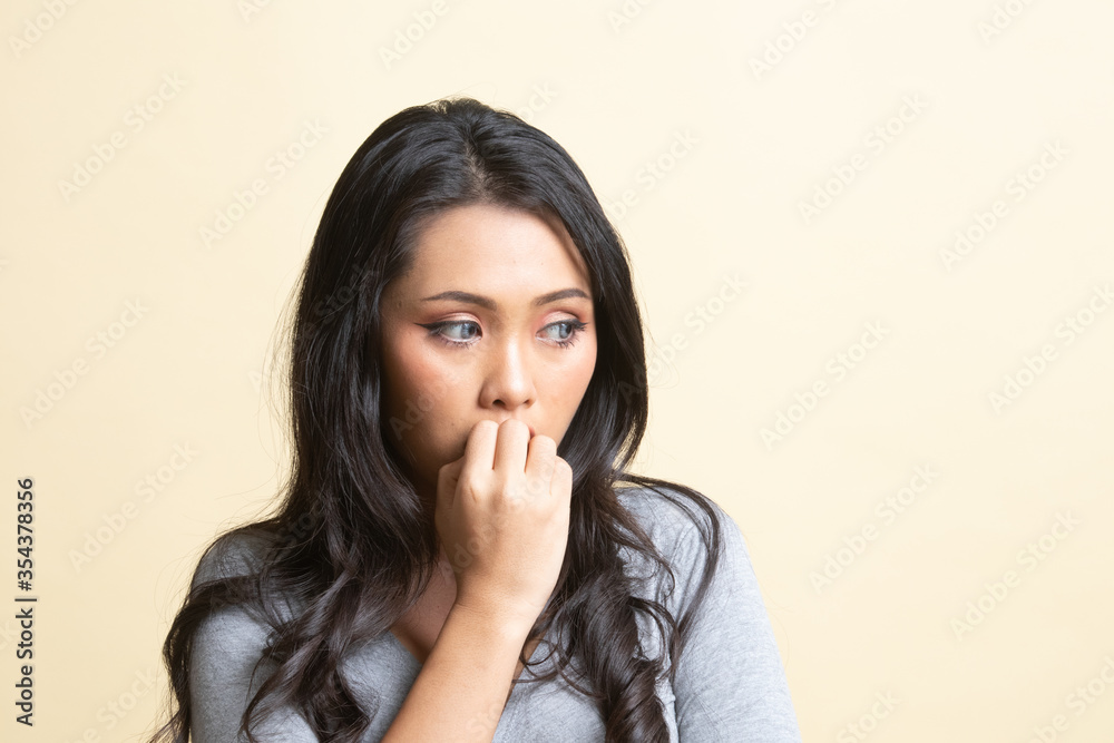 Unsure hesitant nervous young asian woman biting her fingernails. Unsure hesitant nervous young asian woman biting her fingernails.