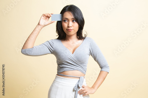 Young Asian woman think with a blank card.