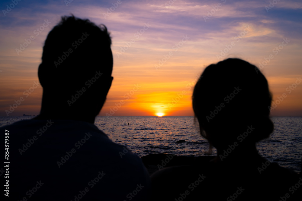 Couple looking the sunset on the beach.
