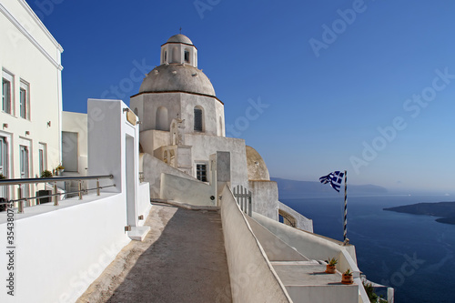 Small orthodox church with Greek flag in Fira,Santorini island,Greece