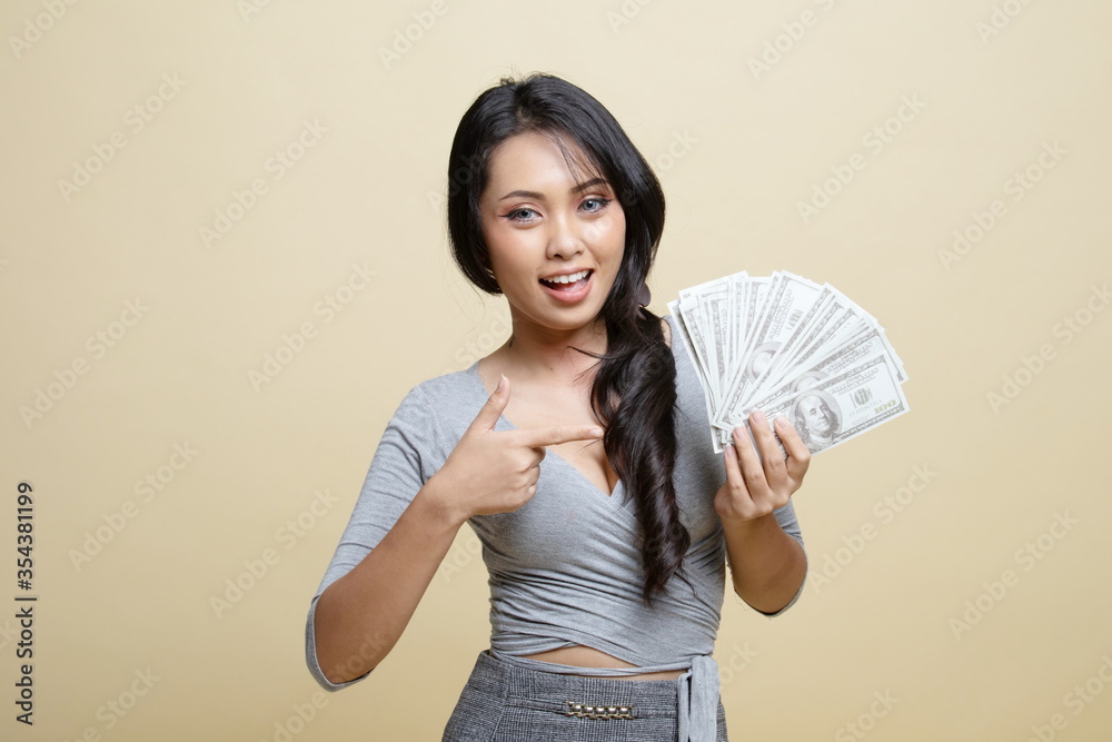 Portrait of young asian woman showing bunch of money banknotes. Portrait of young asian woman showing bunch of money banknotes.