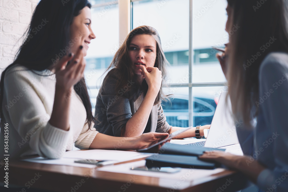 Fototapeta premium Modern three female colleagues brainstorming about work