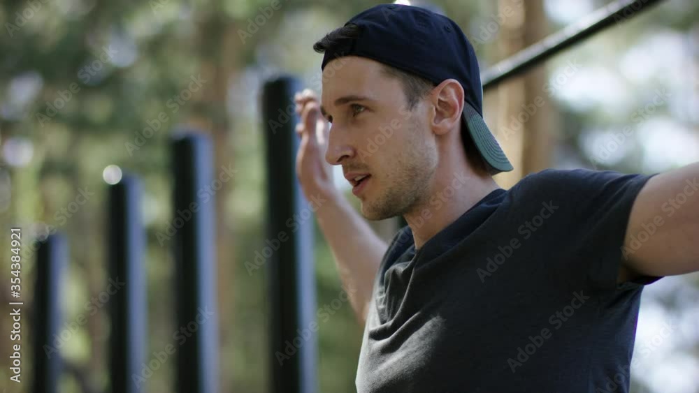 Adult caucasian strong sportsman is warming up his hands before physical exercises at the gym at the park on his daily workout, close up Adult caucasian strong sportsman is warming up his hands before physical exercises at the gym at the park on his daily workout, close up