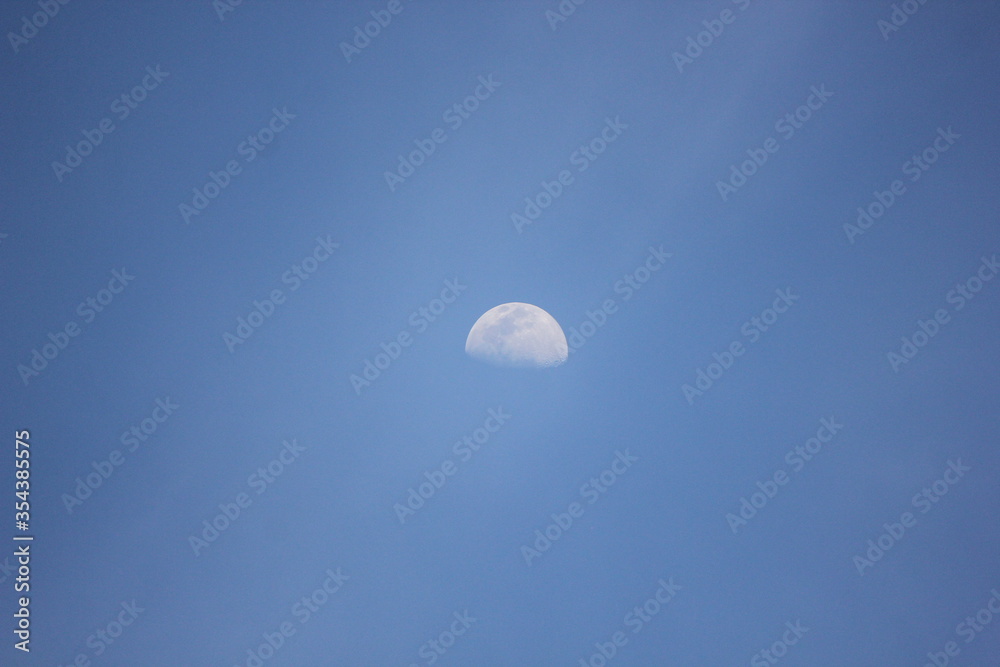 The moon seen during the daytime with a pretty blue sky behind it. The moon seen during the daytime with a pretty blue sky behind it.