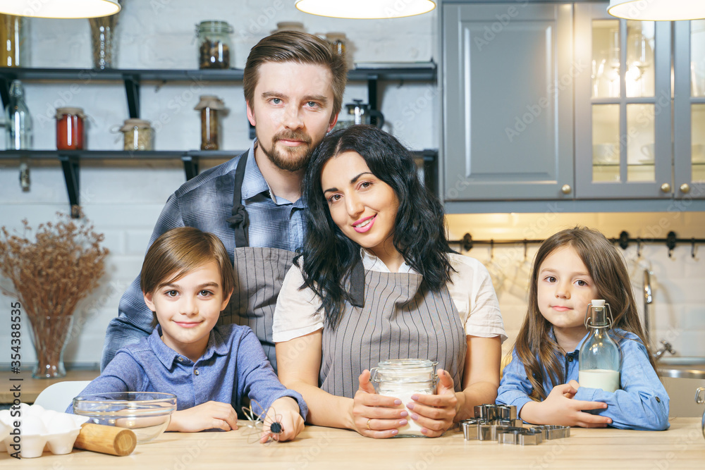 Portrait of a happy family cooking cookies in the kitchen Portrait of a happy family cooking cookies in the kitchen