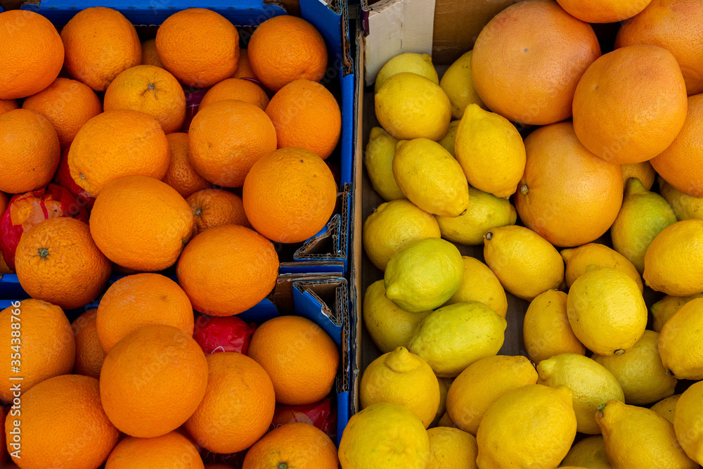 Oranges and lemons close up in boxes on a shop window in an open city market.