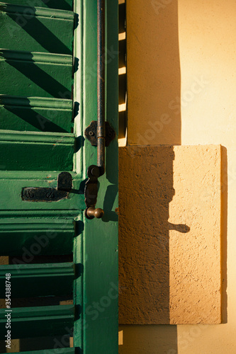 Green shutter on the yellow wall © Sergey Lorgus