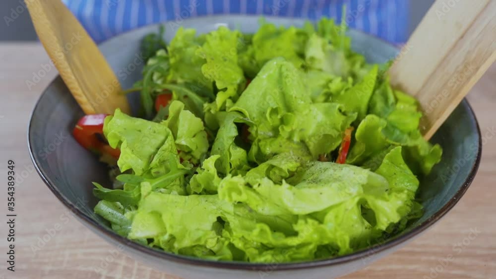 cooking fresh salad in the bowl with red pepper and arugula cooking fresh salad in the bowl with red pepper and arugula