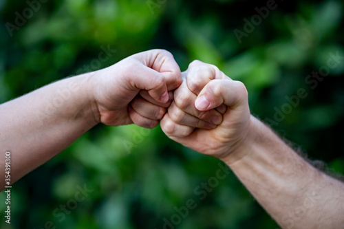 clash of fists, concept of competition, on a green background © josecarlos