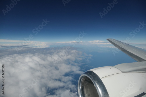 avion vue hublot ciel bleu et nuages en bas