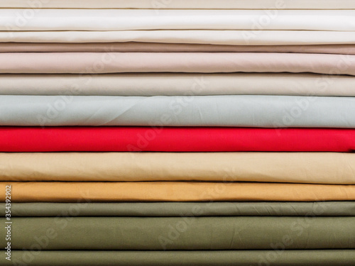 Samples of viscose in pastel pleasant colors close-up. The fabric is laid in layers on the shelves of the fabric store. Fashionable fabrics and colors for tailoring the clothing collection