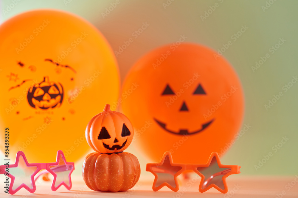 Bright halloween decoration for holiday. Glasses and air balloons on green background. Autumn festive event concept Bright halloween decoration for holiday. Glasses and air balloons on green background. Autumn festive event concept