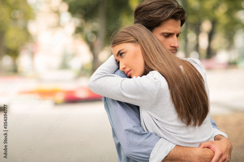 Fototapeta premium Sad Guy And Girl Hugging Feeling Unloved Standing Outdoors