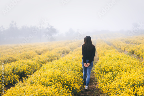 Adult asia traveller woman walking relax in yellowe park field on morning. © dodotone