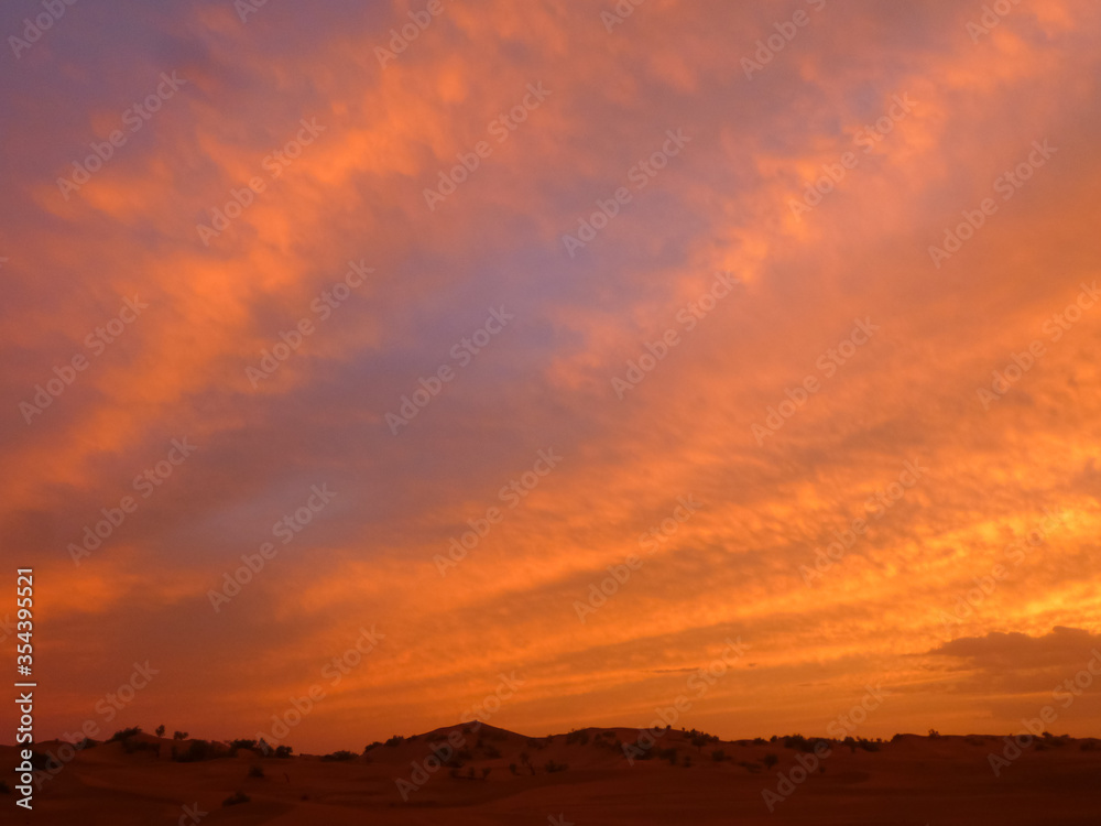 Sunset over Sahara desert with gentle colours and clouds Sunset over Sahara desert with gentle colours and clouds