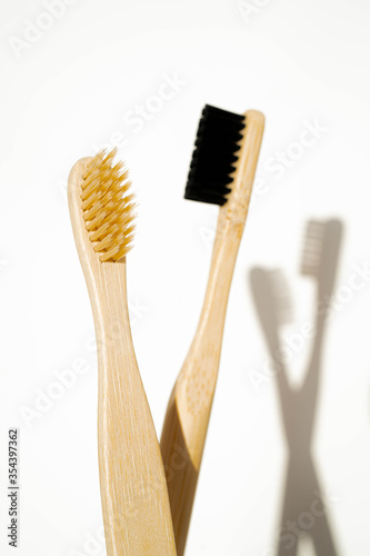 Eco-friendly bamboo toothbrushes on wooden background. Natural organic bathroom beauty product concept. Flat lay  top view  copy space.