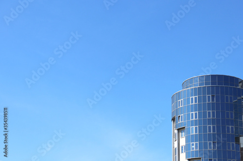 Glass modern building on the blue sky background with space for text. Business background with copy space for text.