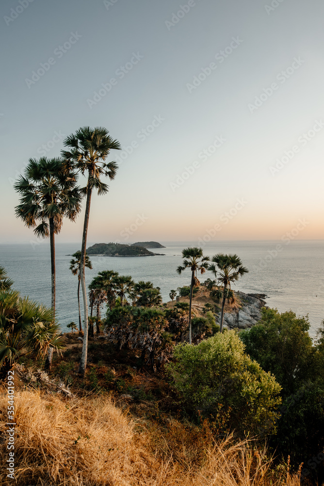Thailand, 2020: mountain viewpoint on sunset above the ocean with trees tops on foreground