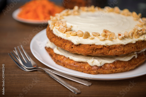 Carrot cake, hazel nuts and grated carrot on the wooden table