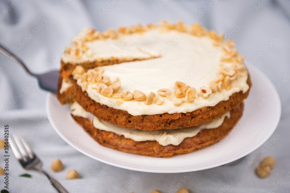 Carrot cake and hazel nuts on the white tablecloth Carrot cake and hazel nuts on the white tablecloth