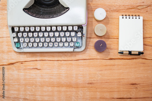 Tableau sur toile old wooden background with typewriter, notepad, candles