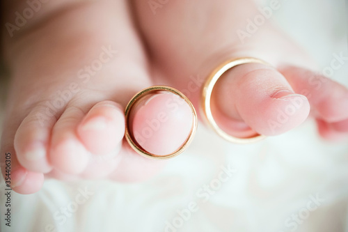 Detalle de anillos de una pareja recién casada colocados en los dedos de unos pies de bebé recién nacido