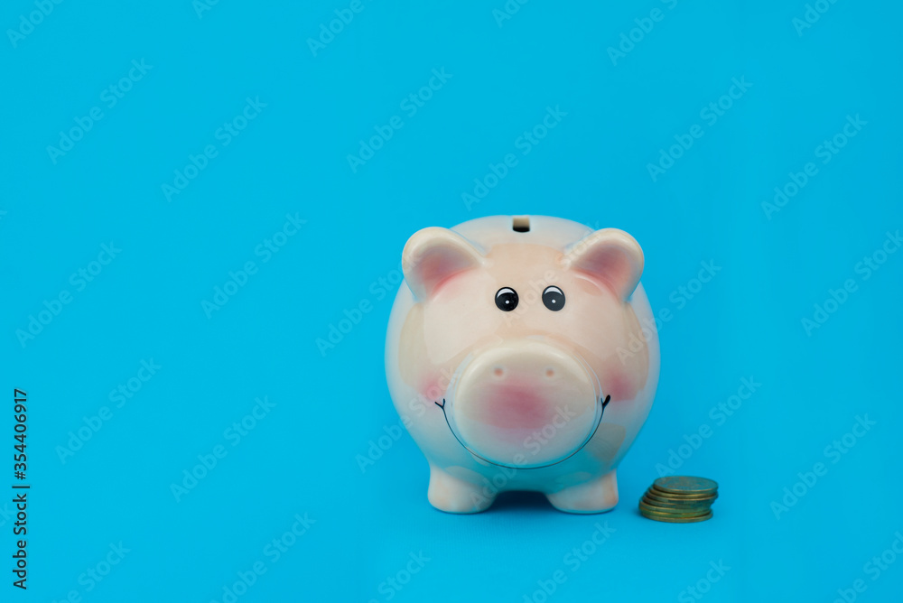 pink piggy file for saving money in a bank with coins on a blue background