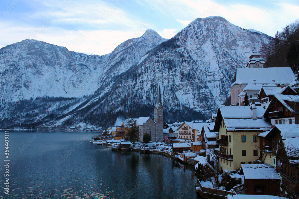 Postcard of Hallstatt, Austria in Winter time. The mountains, the roofs full of snow and the cold colours, make this one the best scenes of this amazing village. 