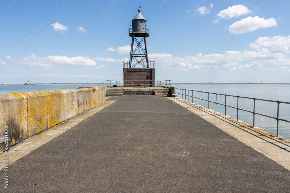  lighthouse stands at the end of a pier at the North Sea