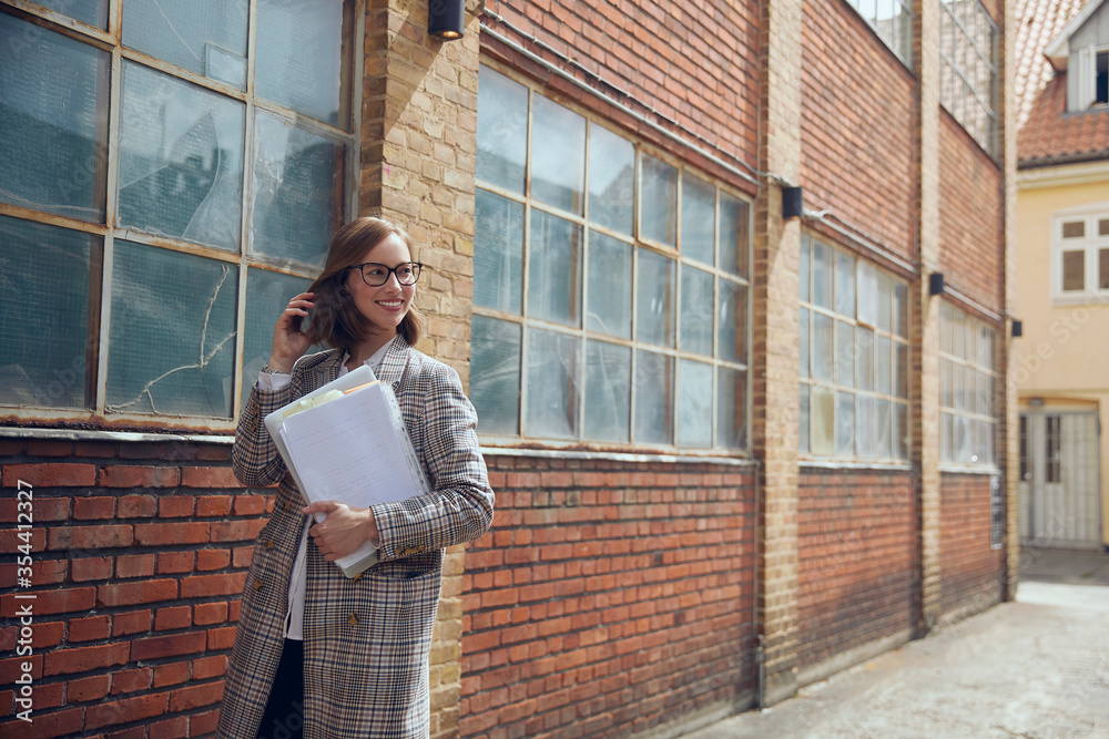 Fototapeta premium Young business woman walking by a nice old new yourker building