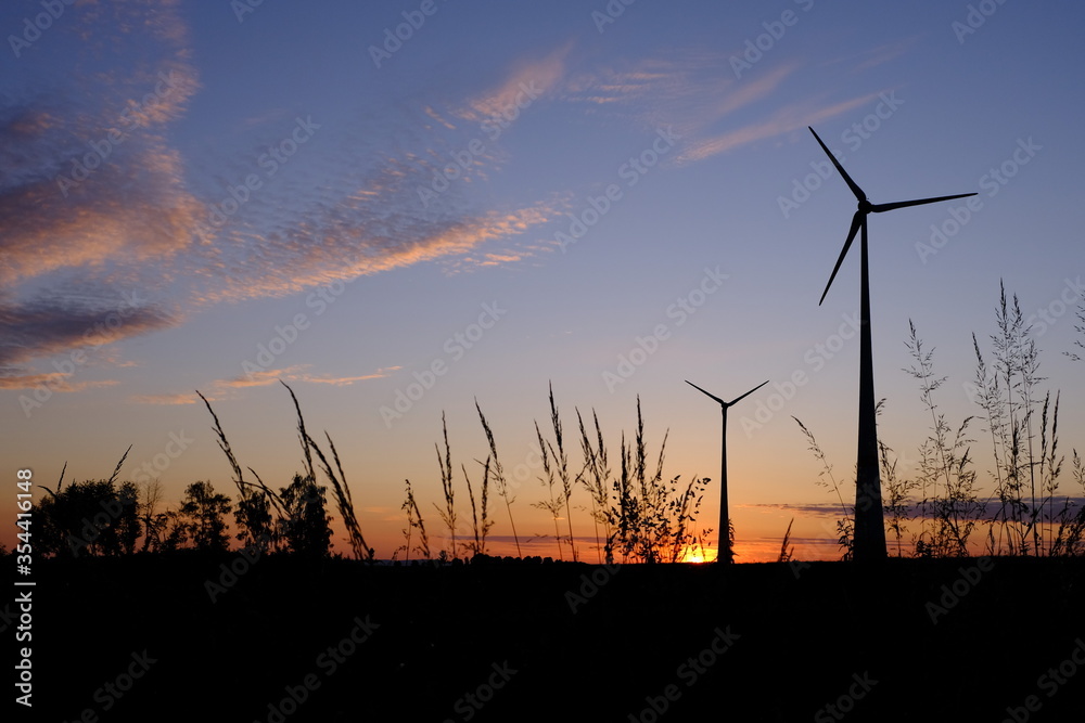 Obraz premium Silhouette von Windkrafträdern im Sonnenaufgang