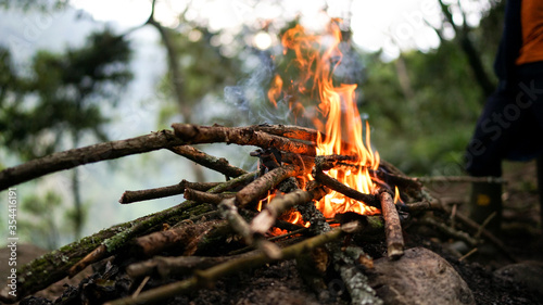 Campfire in the forest to get warm and cook food for dinner, summer nights, trekking and hiking in the mountains
